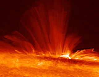 Sonnenfleck mit Strömen von superheißem, elektrisch geladenem Gas (Plasma), die von der Oberfläche der Sonne ausstrahlen und die Struktur des solaren Magnetfelds offenbaren. Wissenschaft Astronomie